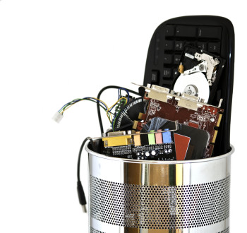 Metal trash can containing computer waste isolated on white background